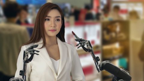 une femme asiatique se fait maquiller par un robot