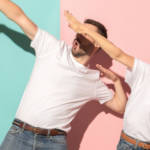 deux personnes en t-shirt blanc font des gestes de victoire sur fond bleu et rose