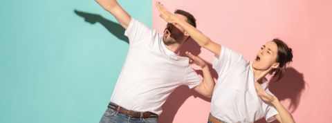 deux personnes en t-shirt blanc font des gestes de victoire sur fond bleu et rose