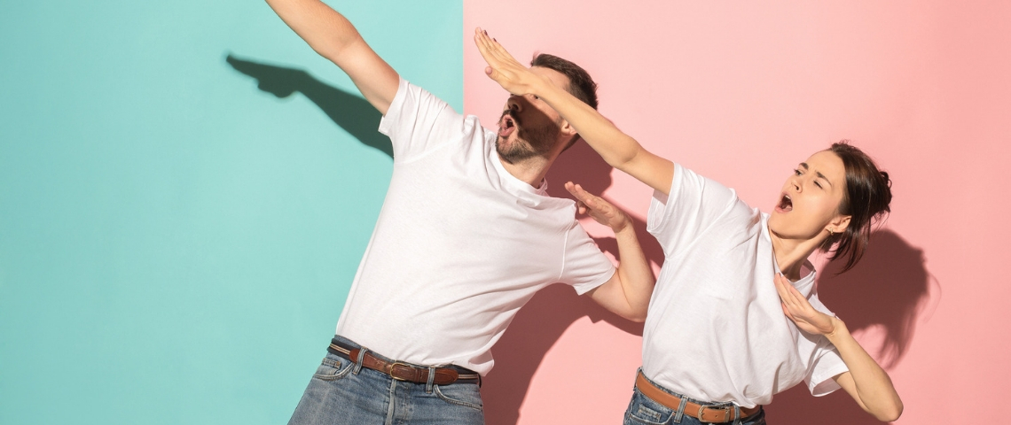 deux personnes en t-shirt blanc font des gestes de victoire sur fond bleu et rose