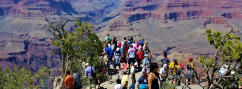 Des touristes regardent l'horizon au bord d'une falaise