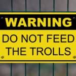 Pancarte indique "Warning do not feed the trolls"