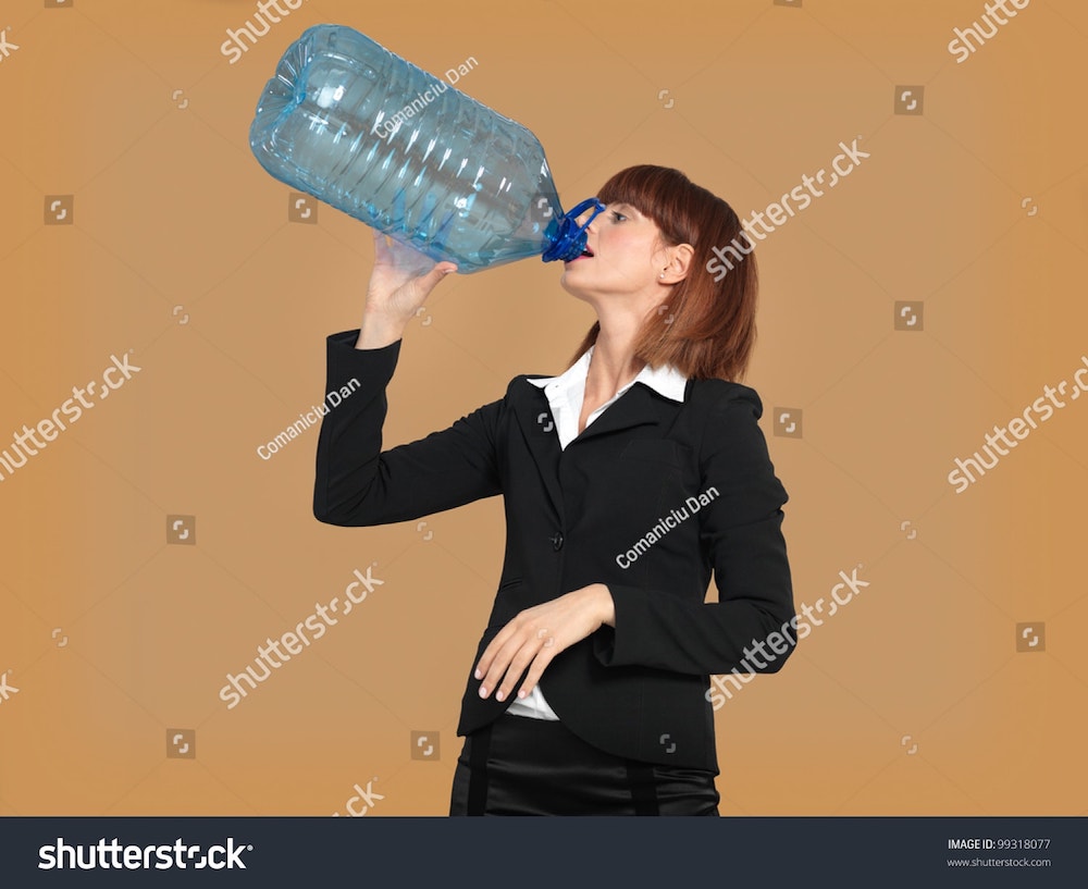une femme boit la fontaine à eau à la bouteille