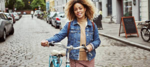 Une femme qui marche à côté de son vélo dans une ville