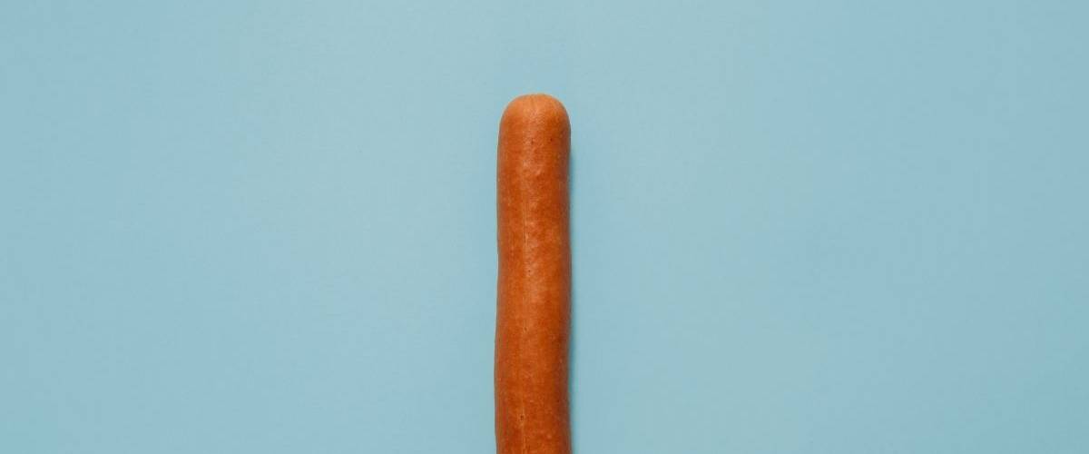 Une saucisse sur fond bleu pastell