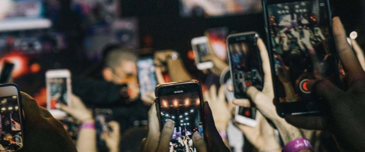Instagram ajoute les Stories dans sa section Explorer Une foule de téléphone film un concert.