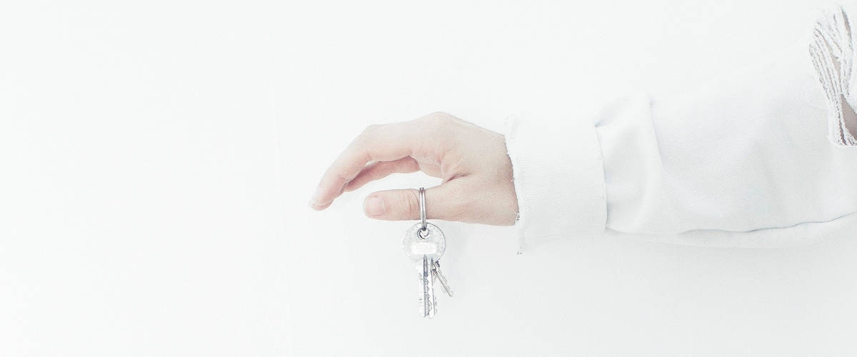 airbnb Une mùain sur fond blanc tient une clés