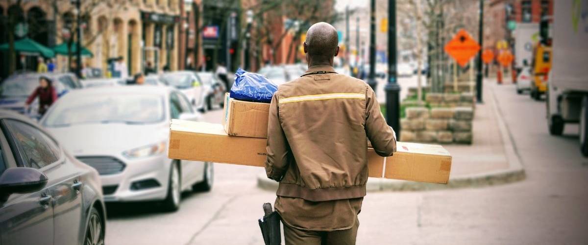 Amazon paie se employés pour qu’ils démissionnent et deviennent livreurs Un homme, de dos, porte des colis.