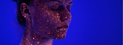 Les marques qui se mettent à l'astrologie Une femme avec des paillettes sur le visage sur un fond bleu