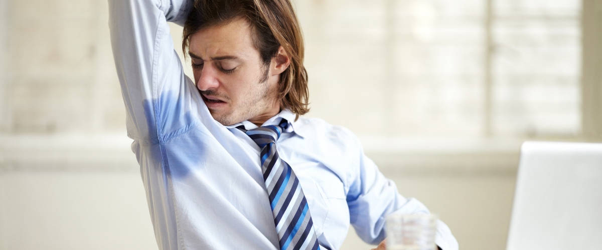 66% des Français sont gênés par leurs collègues de bureau Un homme en chemise et cravate se sent les aisselles humides
