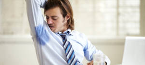 Un homme en chemise et cravate se sent les aisselles humides