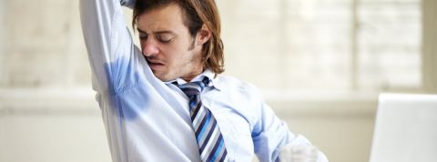 66% des Français sont gênés par leurs collègues de bureau Un homme en chemise et cravate se sent les aisselles humides