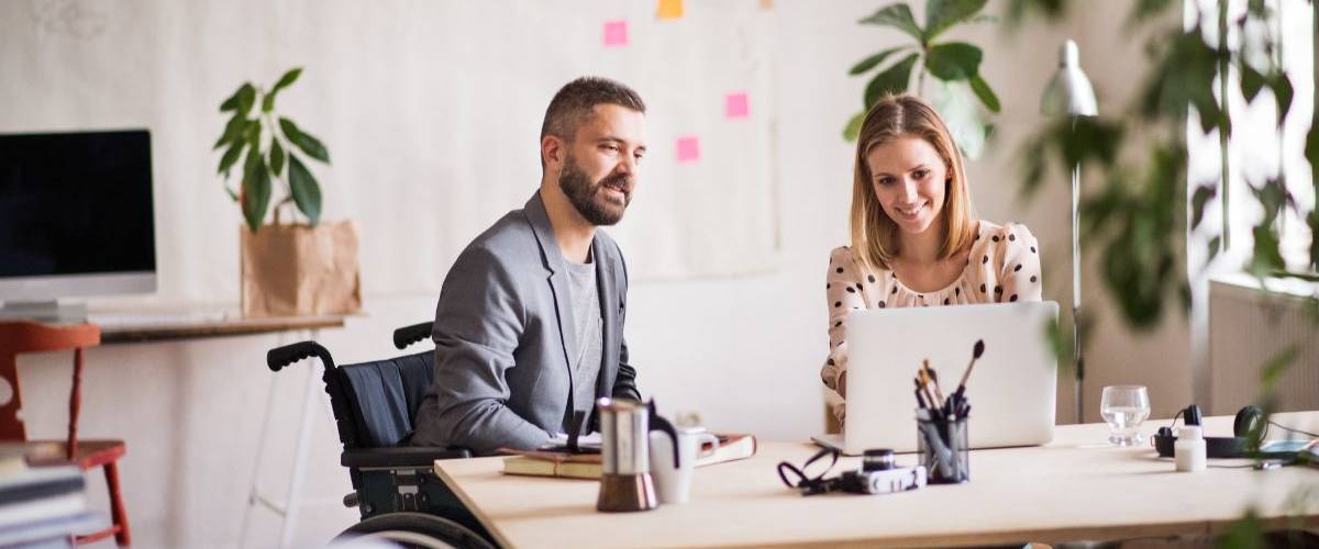 Getty Images fête les un an de sa collection Disability Collection Une femme et un homme en fauteuil roulant discutent dans un bureau