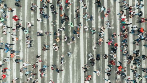 Une foule de gens en train de traverser à un passage piéton