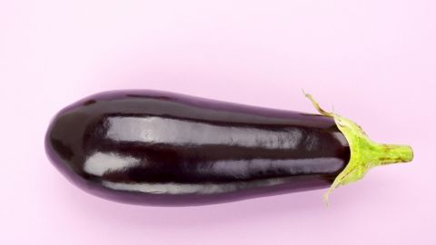 une aubergine sur un fond rose