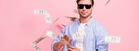 Quelles sont les entreprises qui payent le mieux en France ? Un homme avec des lunettes de soleil en train de jouer avec des billets de banque