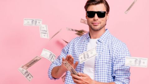 Quelles sont les entreprises qui payent le mieux en France ? Un homme avec des lunettes de soleil en train de jouer avec des billets de banque