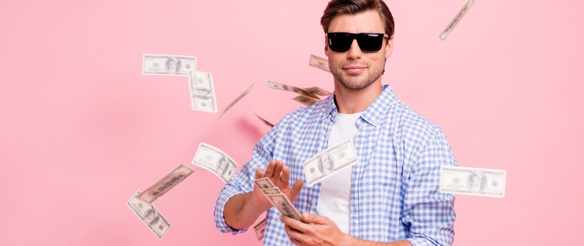 Quelles sont les entreprises qui payent le mieux en France ? Un homme avec des lunettes de soleil en train de jouer avec des billets de banque