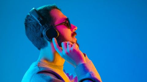 un homme portant des moustache vue de profil en train de mettre un casque sur les oreilles.