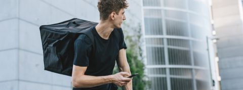 Comment les utilisateurs d'applications peuvent-ils changer les conditions de travail des livreurs ? Un homme à vélo avec un sac à dos pour livrer des produits alimentaires