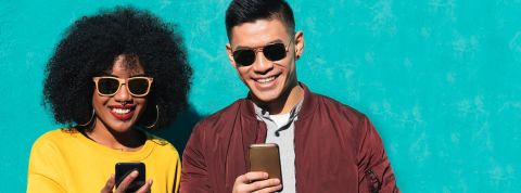 Où acheter son appareil reconditionnement Deux amis heureux devant leur smartphone.