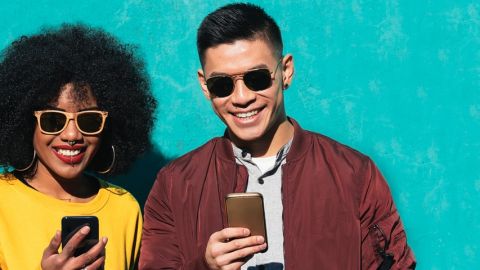 Deux amis heureux devant leur smartphone.