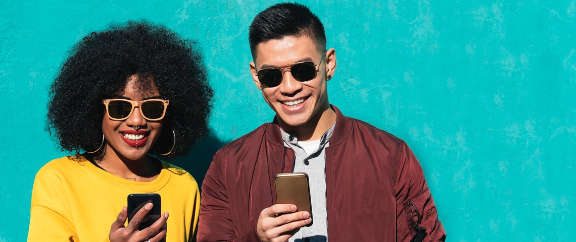 Où acheter son appareil reconditionnement Deux amis heureux devant leur smartphone.