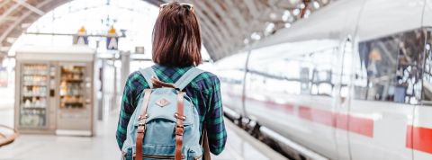 Transformation RH : comment la SNCF forme ses agents Une jeune fille de dos sur le quai d'une gare avec un sac à dos