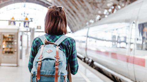 Transformation RH : comment la SNCF forme ses agents Une jeune fille de dos sur le quai d'une gare avec un sac à dos