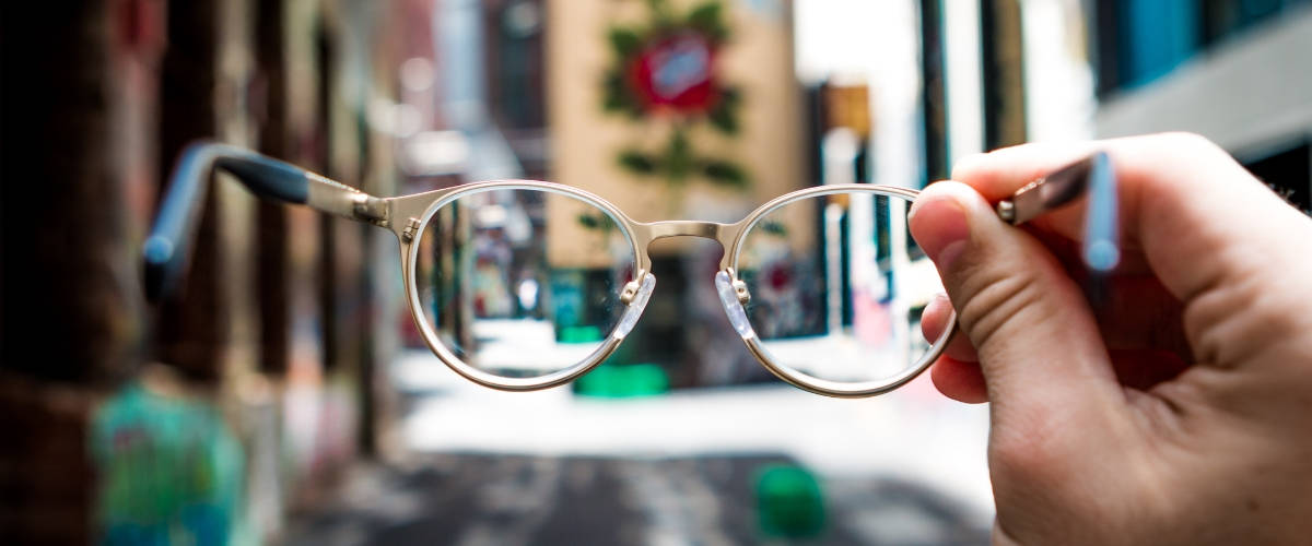 Krys réalise le 1er parcours Instagrammable en France Une main tenant une paire de lunettes dans une rue