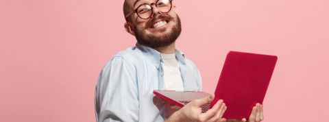 Tendances : qui sont les maniaques du web ? Un homme à lunettes est heureux avec son ordinateur portable
