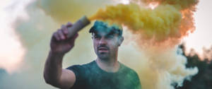 Un jeune brandit une bombe de fumée colorée
