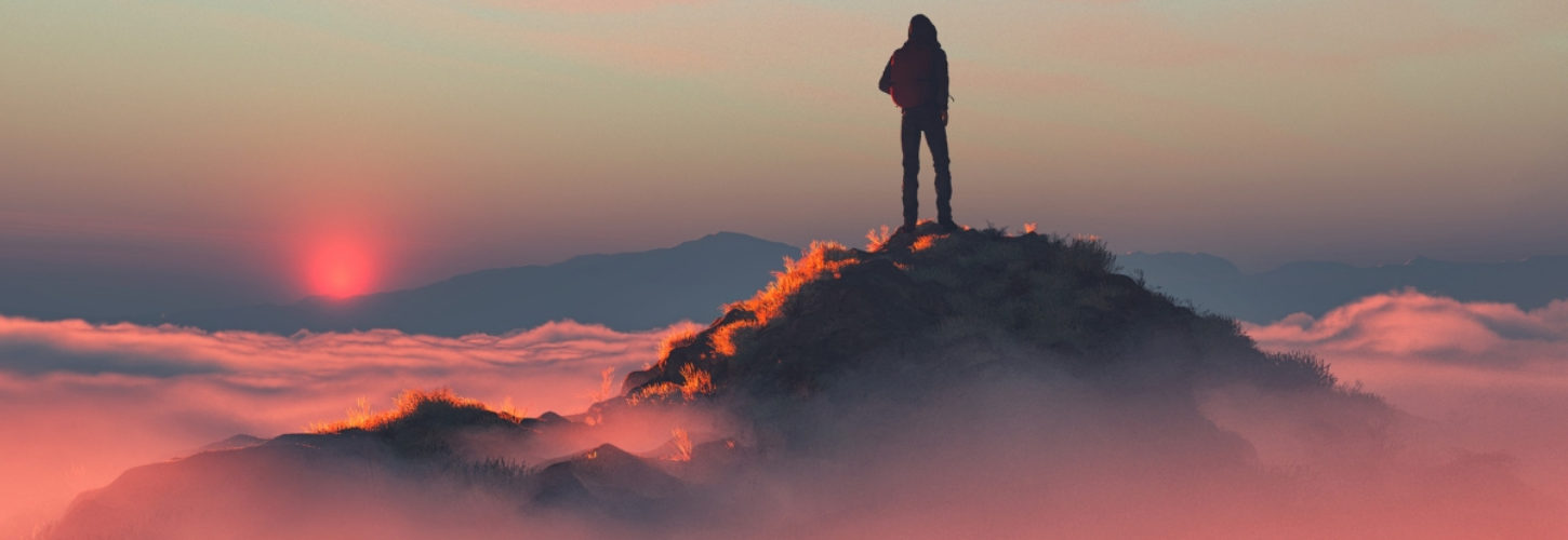 Comment être en tête des résultats sur Amazon ? Un homme au sommet d'une montagne au dessus des nuages roses