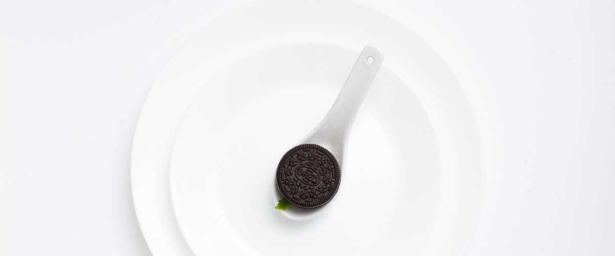 Mondelez va produire des biscuits au cannabis Biscuit Oreo placé dans une assiette blanche, sur fond blanc minimaliste