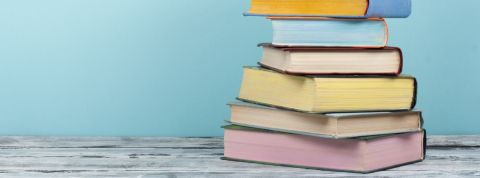 Quels sont les livres à lire en 2019 ? Une pile de livres aux couleurs pastels sur un fond bleu