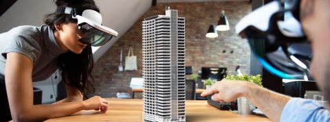 Collaborer à distance sera bientôt possible avec la réalité augmentée deux personnes équipée de casque de réalité augmentée travaille autours d'une maquette de building