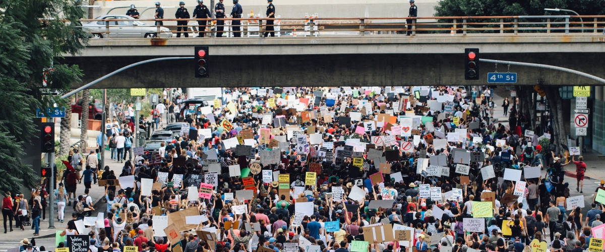 Une start-up veut rémunérer les manifestants Une foule de manifestants traverse le dessous d'un pont.