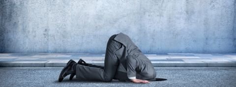 Les entreprises n'ont plus le choix : elles doivent se mettre à la RSE Un homme en costume de travail la tête dans le goudron