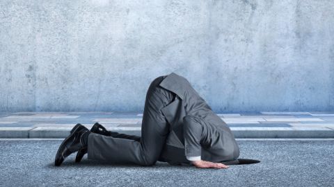 Un homme en costume de travail la tête dans le goudron