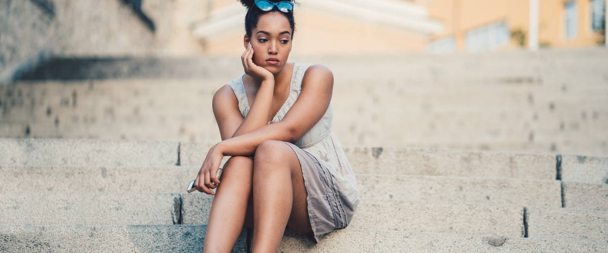 Après 23 ans, c'est plus difficile de se faire des amis Une femme assise seule sur un escalier