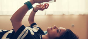 Une adolescente allongée sur son lit en train de lire d'envoyer des textos