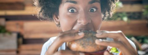 Les milliardaires de la tech misent plein pot sur les burgers vegan une jeune femme noire croque dans un burger vegan