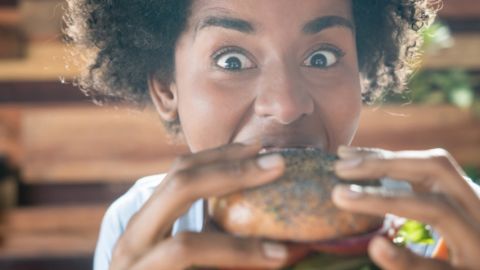 Les milliardaires de la tech misent plein pot sur les burgers vegan une jeune femme noire croque dans un burger vegan