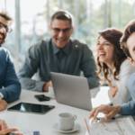 Groupe de salariés hilares autour d'une table de réunion