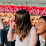 trois filles qui rient devant des fleurs
