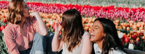 À quoi rêvent les jeunes femmes d’aujourd’hui ? trois filles qui rient devant des fleurs
