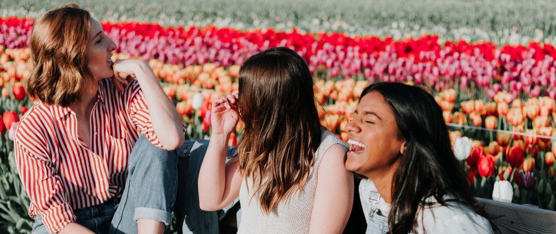 À quoi rêvent les jeunes femmes d’aujourd’hui ? trois filles qui rient devant des fleurs