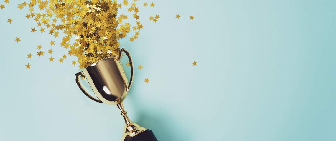 Pourquoi faut-il absolument communiquer sur ses performances ? Un trophée rempli de paillettes étoilées