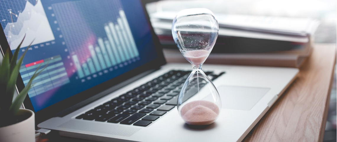 Combien de temps devrions-nous travailler pour être en bonne santé ? Un sablier posé sur un ordinateur portable