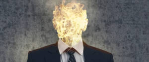 Un homme en costume dont la tête est enflammée